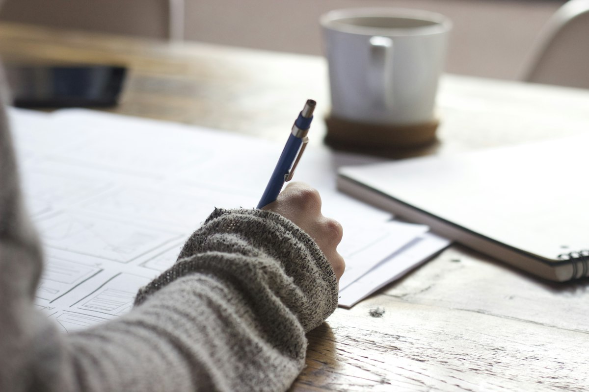 Persona tomando notas en su cuaderno